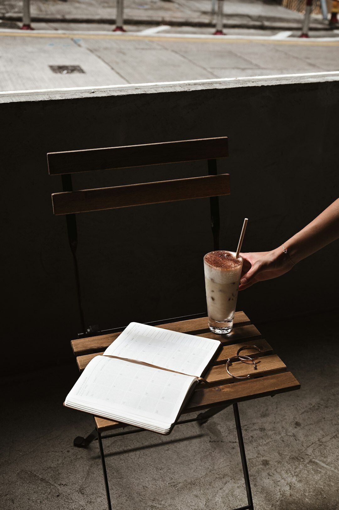 Person writing notes in a notebook at a cafe